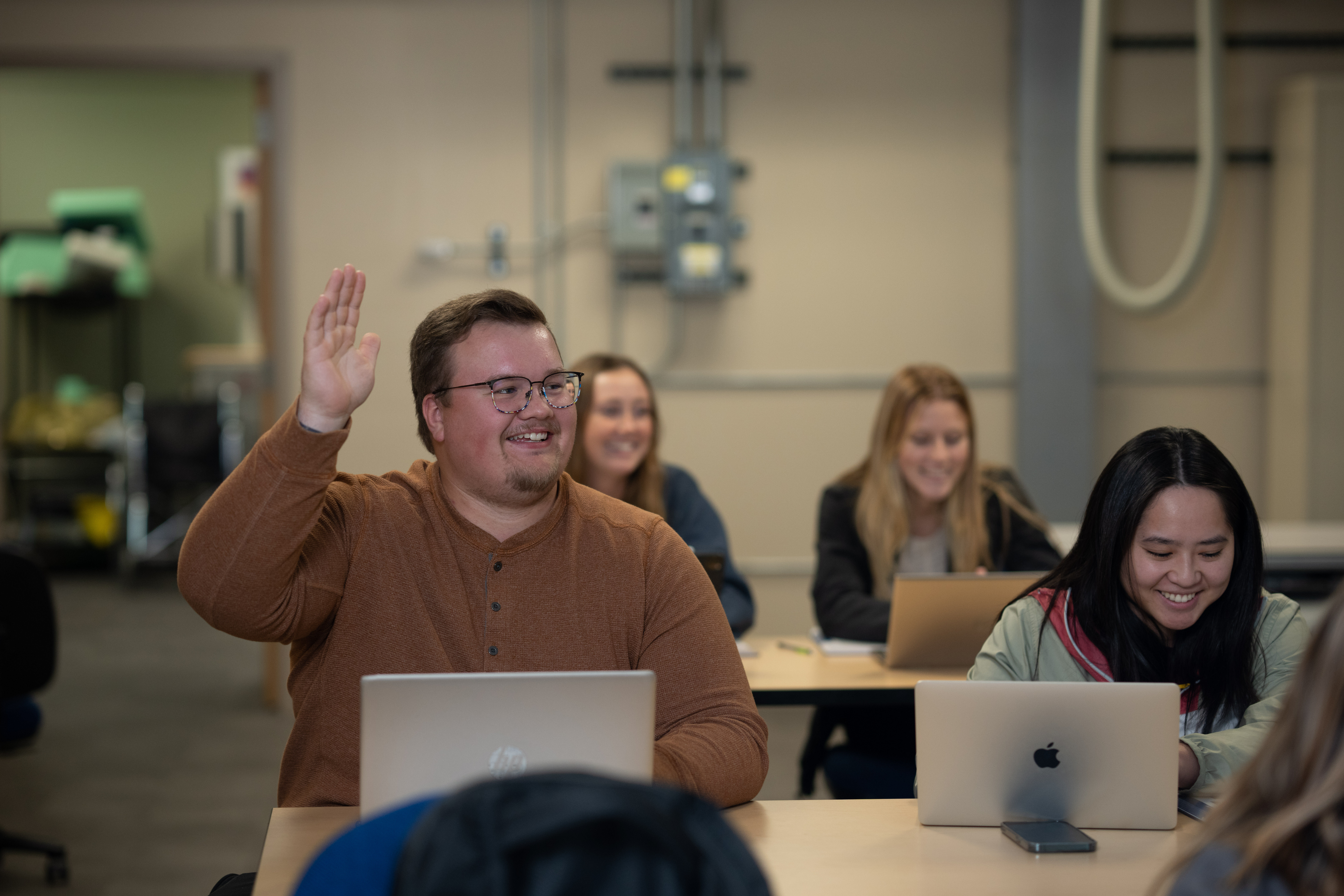 M State student raising his hand in a DL classroom