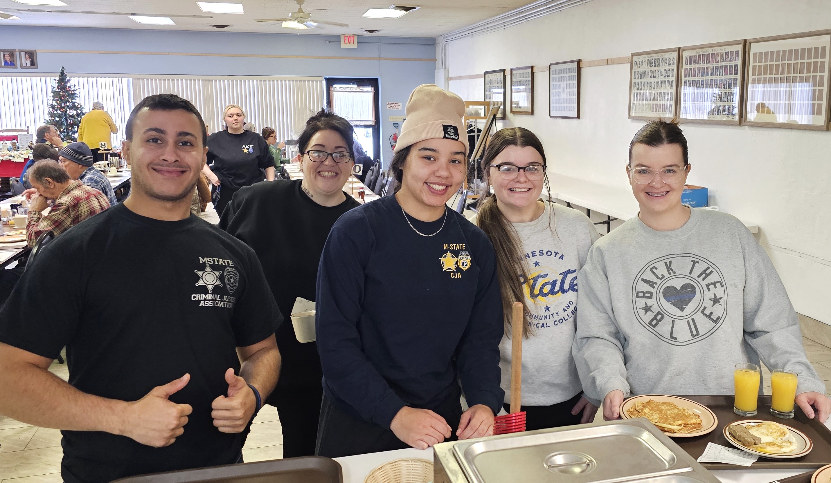 M State Criminal Justice students Binyad Brifki, Lacey Tesla, Sasha Dua, Tristan Altepeter and Lydia Moore, left to right, foreground, and Lily Tesla, walking in the background, serve meals at one of the Moorhead Masonic Lodge’s weekly Pancake Breakfasts this past winter. The college’s Criminal Justice program has partnered with the Masonic Family to provide the breakfasts for the past eight years.