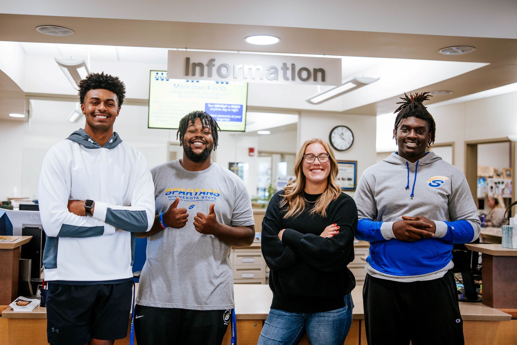 Students stand in front of an information desk