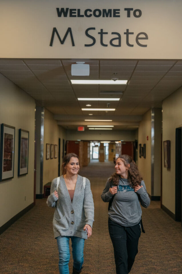 Two students walk down an M State hall