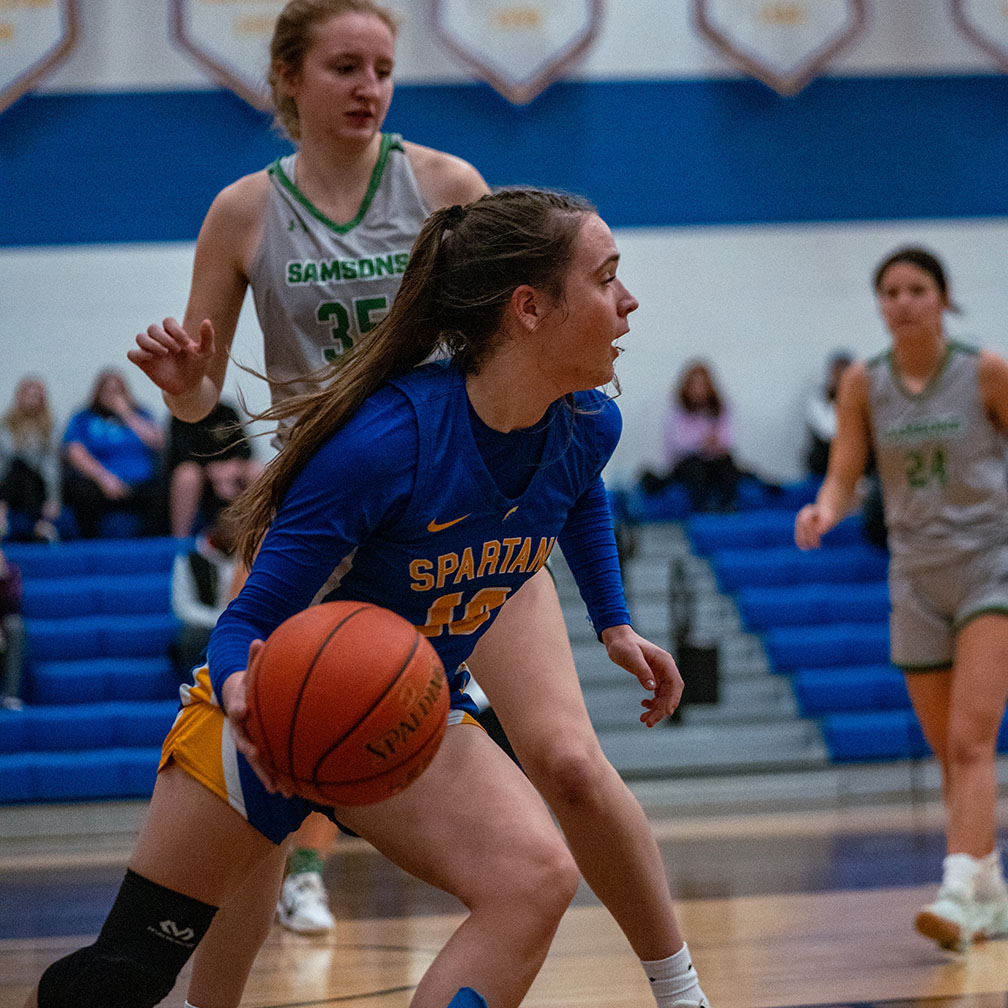 A Spartan basketball player moves up the court