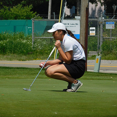 An M State golf player assesses the turf