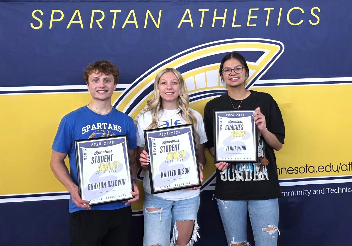Three of the four 2025-2026 Spartans Student Athlete of the Year award winners pose in front of an M State Spartans banner, holding their framed certificates.