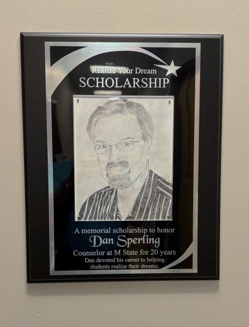 A plaque on the wall of M State Moorhead honoring Dan Sperling, former counselor, and the memorial scholarship created in his honor.