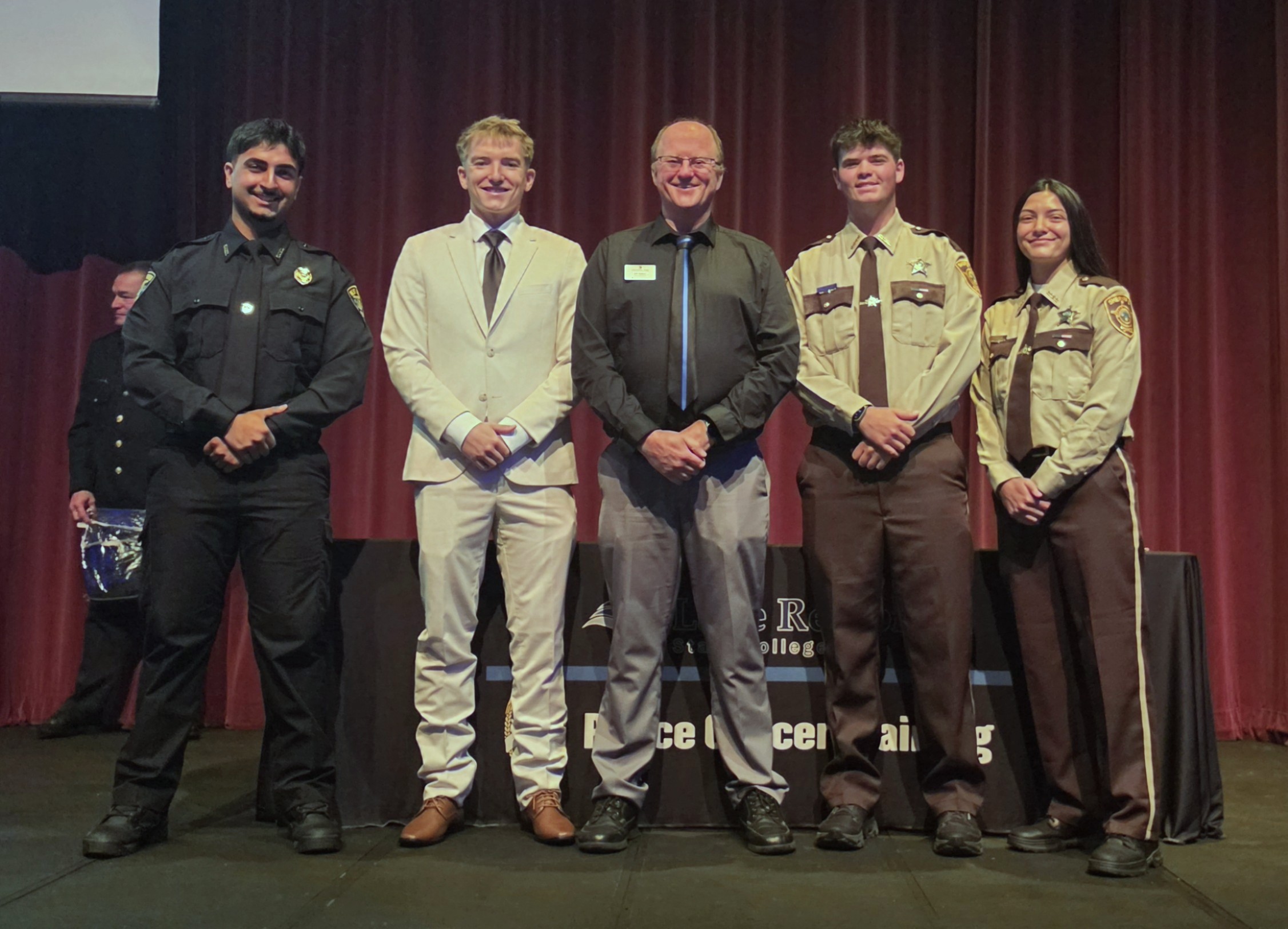 Pictured, from left, are M State Peace Officer Academy graduates Rez Kakayi, Tanner Larson, Carer Jenstead and Destiny Lindgren, with M State Criminal Justice Program Coordinator and Faculty Jeff Nelson, center.