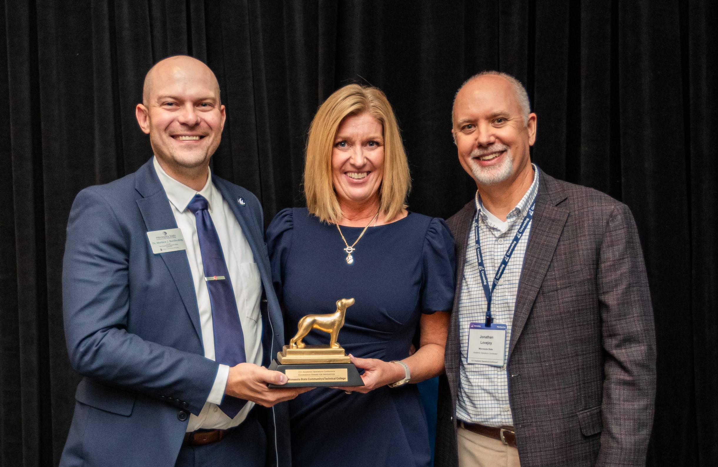 Three M State leaders hold a small gold trophy for the 2025 AcOpscar Innovation Award at a Coursedog conference in Chicago.