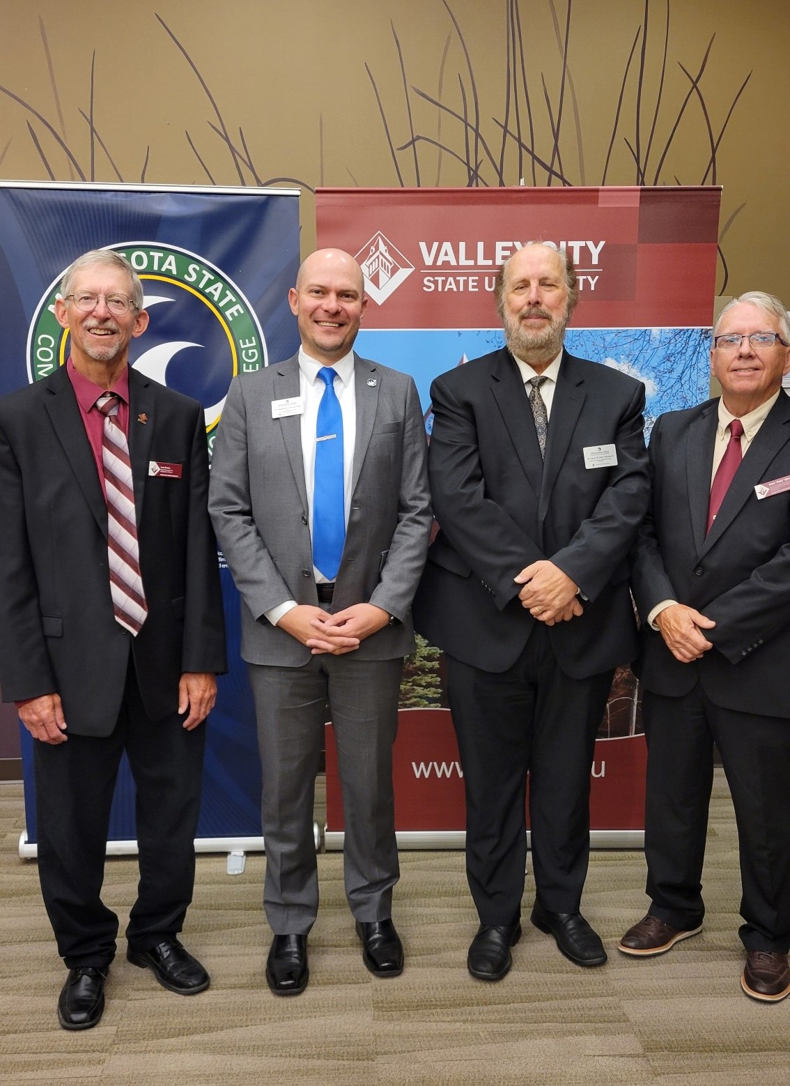 Four college leaders from M State and VCSU stand together for a posed photo following a press conference on M State's Moorhead campus.