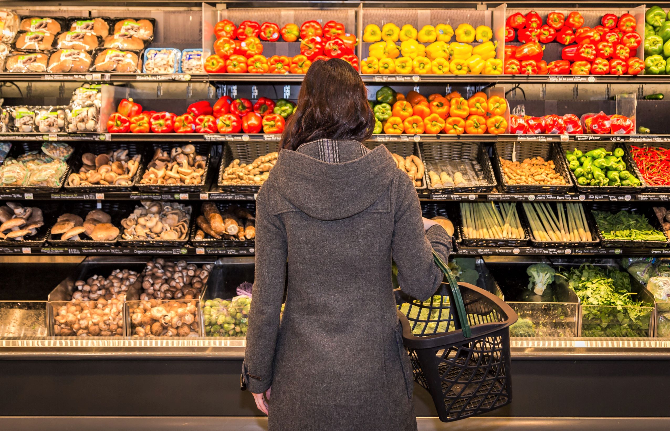 A woman examines produce at the supermarket