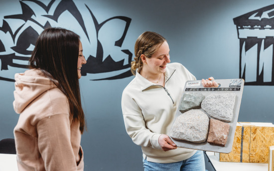 Two students reviewing samples of stone for the architectural drafting and design program