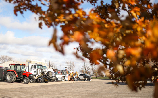 Photo of diesel equipment, like trucks and tractors, that are parked outside during the fall season