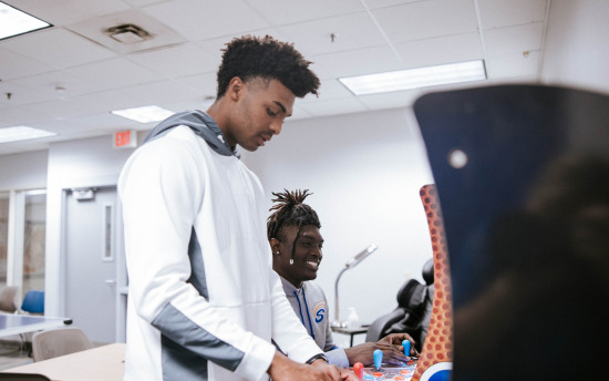 two people playing video games in an office