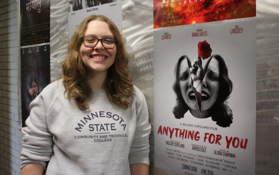 Anna Hayes, Graphic Design student, next to a movie poster she designed, at M State in Moorhead