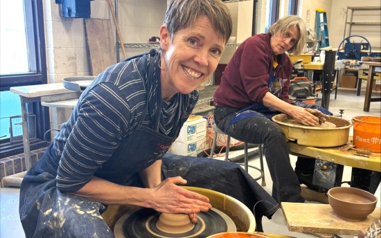 Two potters make ceramic bowls in the M State Fergus Falls art room.