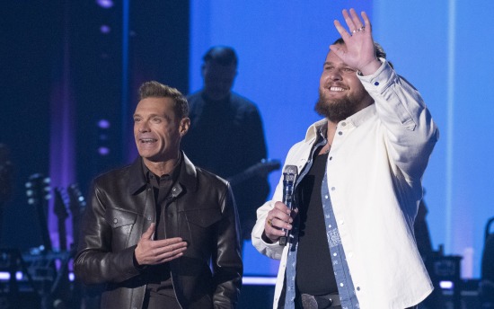 Chris Tungseth waves to the audience onstage at "American Idol" aside show host Ryan Seacrest.