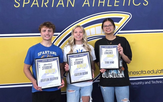 Three Spartans Student Athlete of the Year award winners pose in front of a blue and gold Spartans banner with their award certificates.