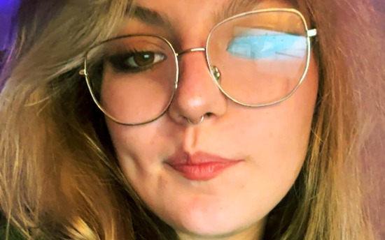 A close-up portrait photo of Addysen Puente, M State student with blond hair and glasses