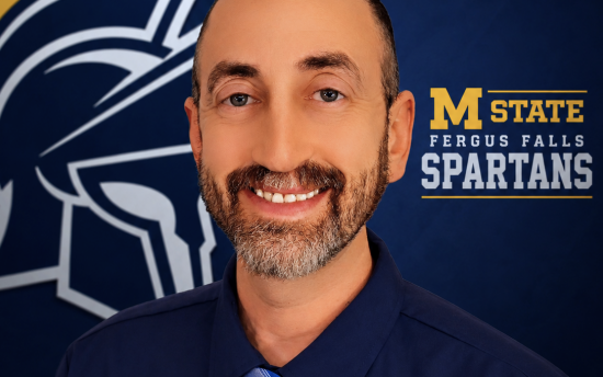 Cropped head shot of women's basketball head coach Steve Schreiber, in front of a blue and yellow Spartans backdrop