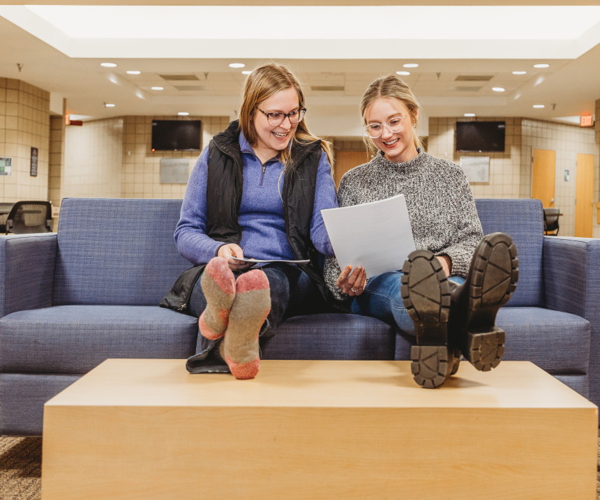 Two students study together in a lounge