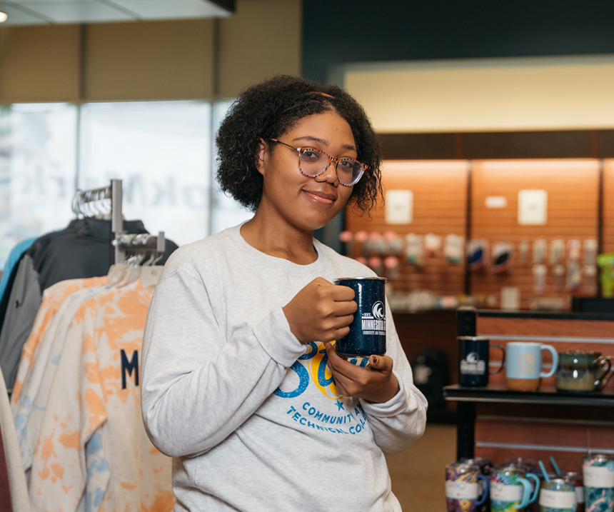 A student holds a new bookstore mug