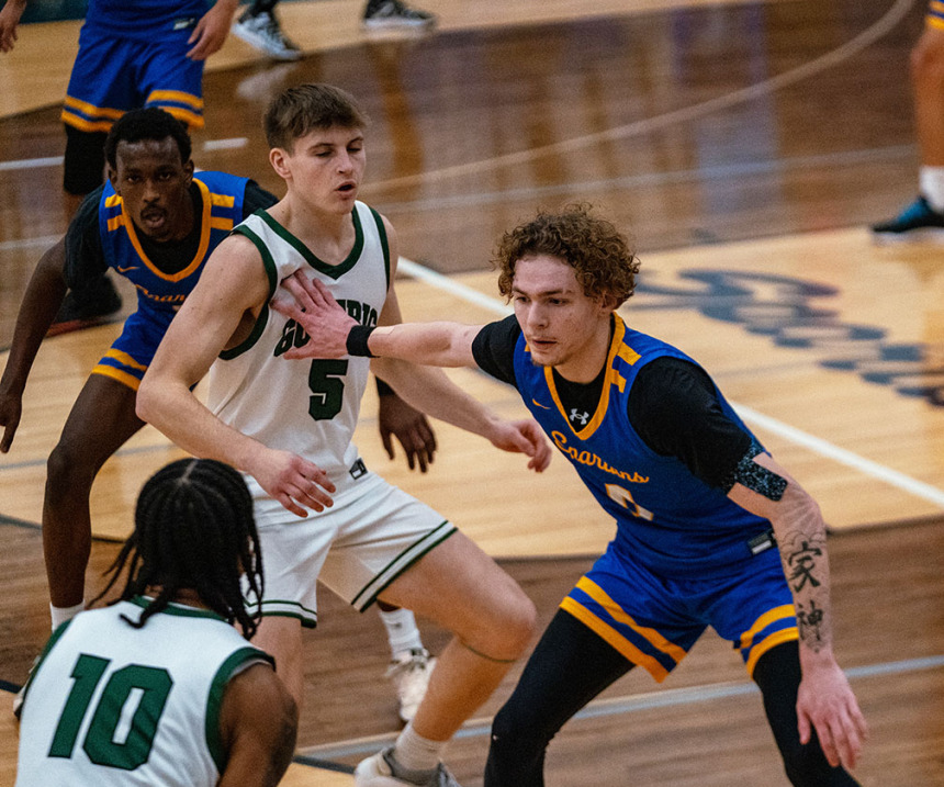 An M State basketball player defends on the court