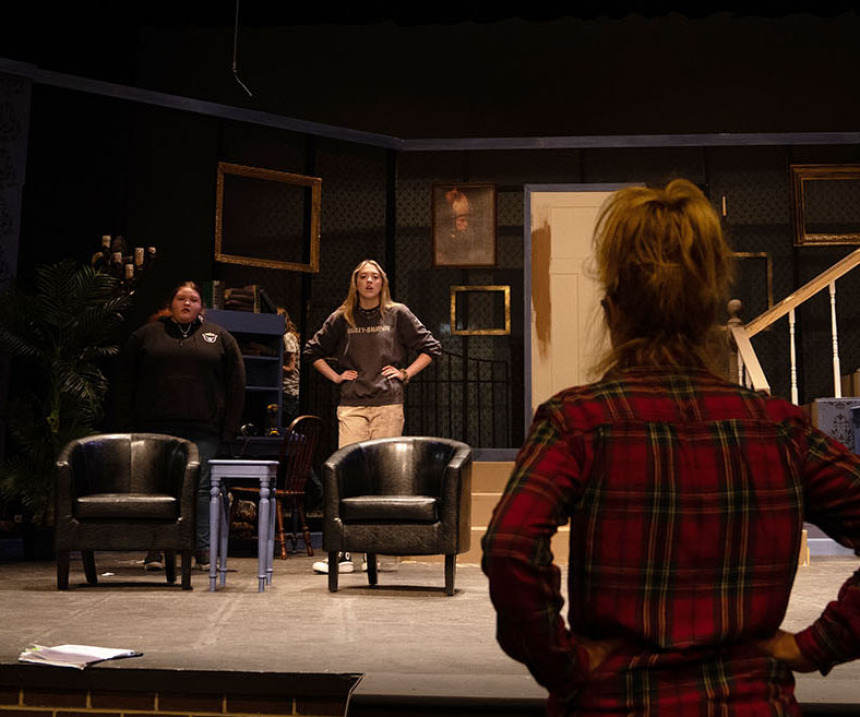 A faculty member watches a theatre rehearsal