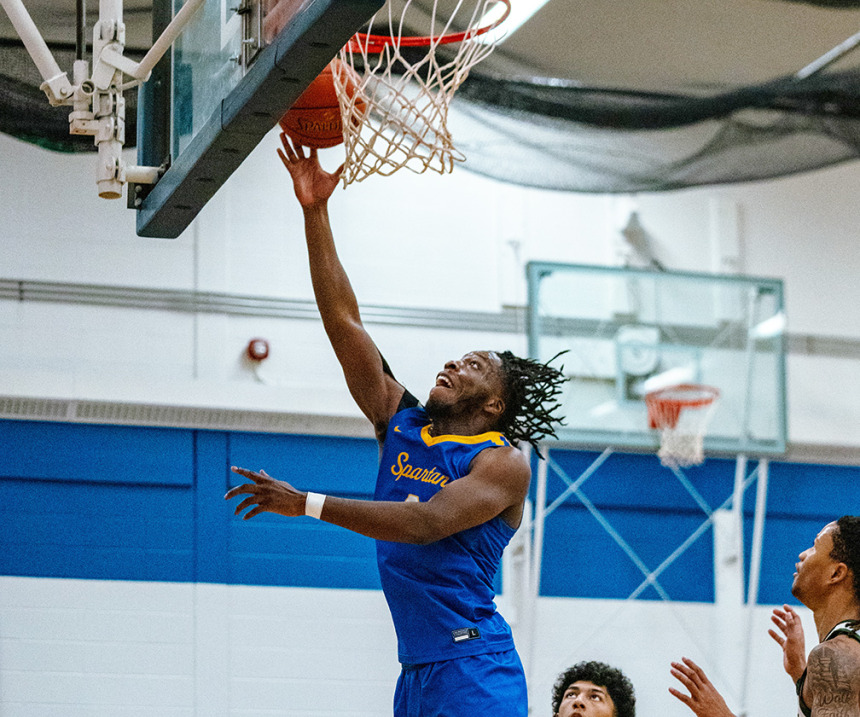 An M State basketball player makes a basket