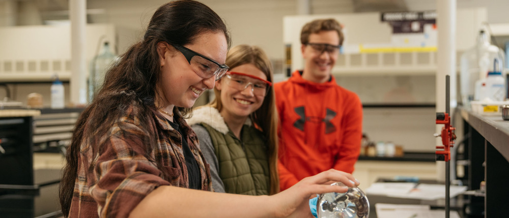 Students with safety glasses work in a lab