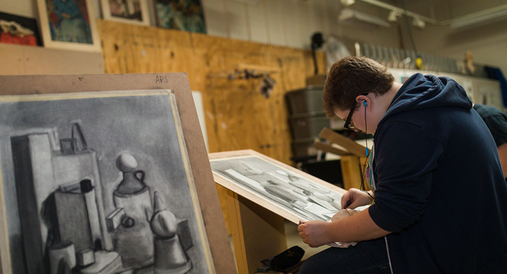 A student draws at an easel