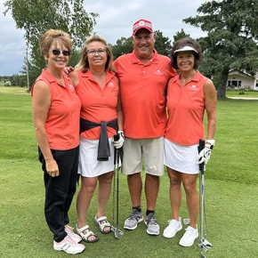 Four golfers pose on the course