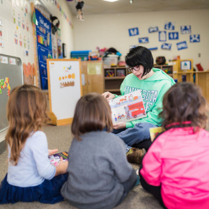 A teacher reads a a book to the class.